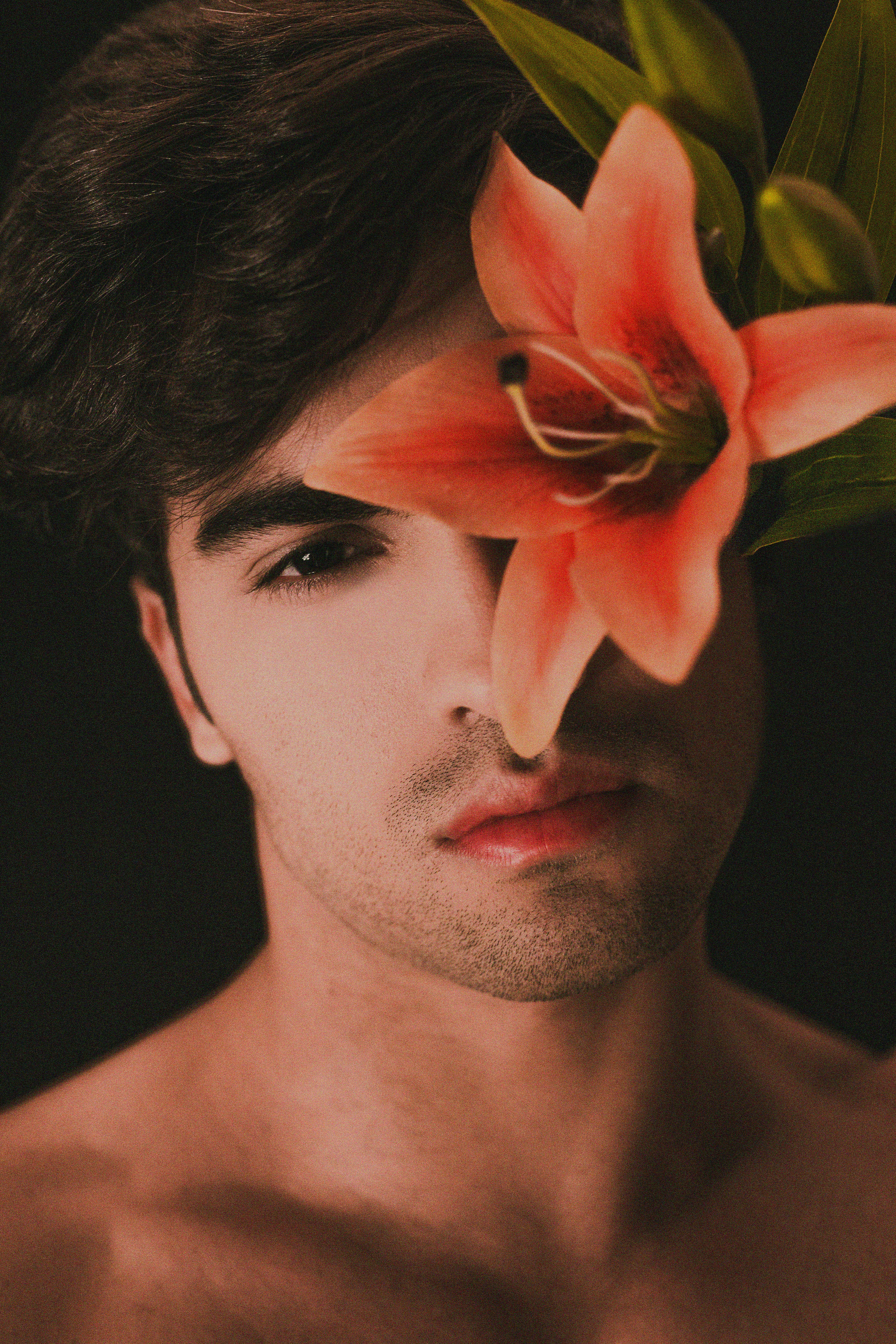 topless man with pink flower on ear